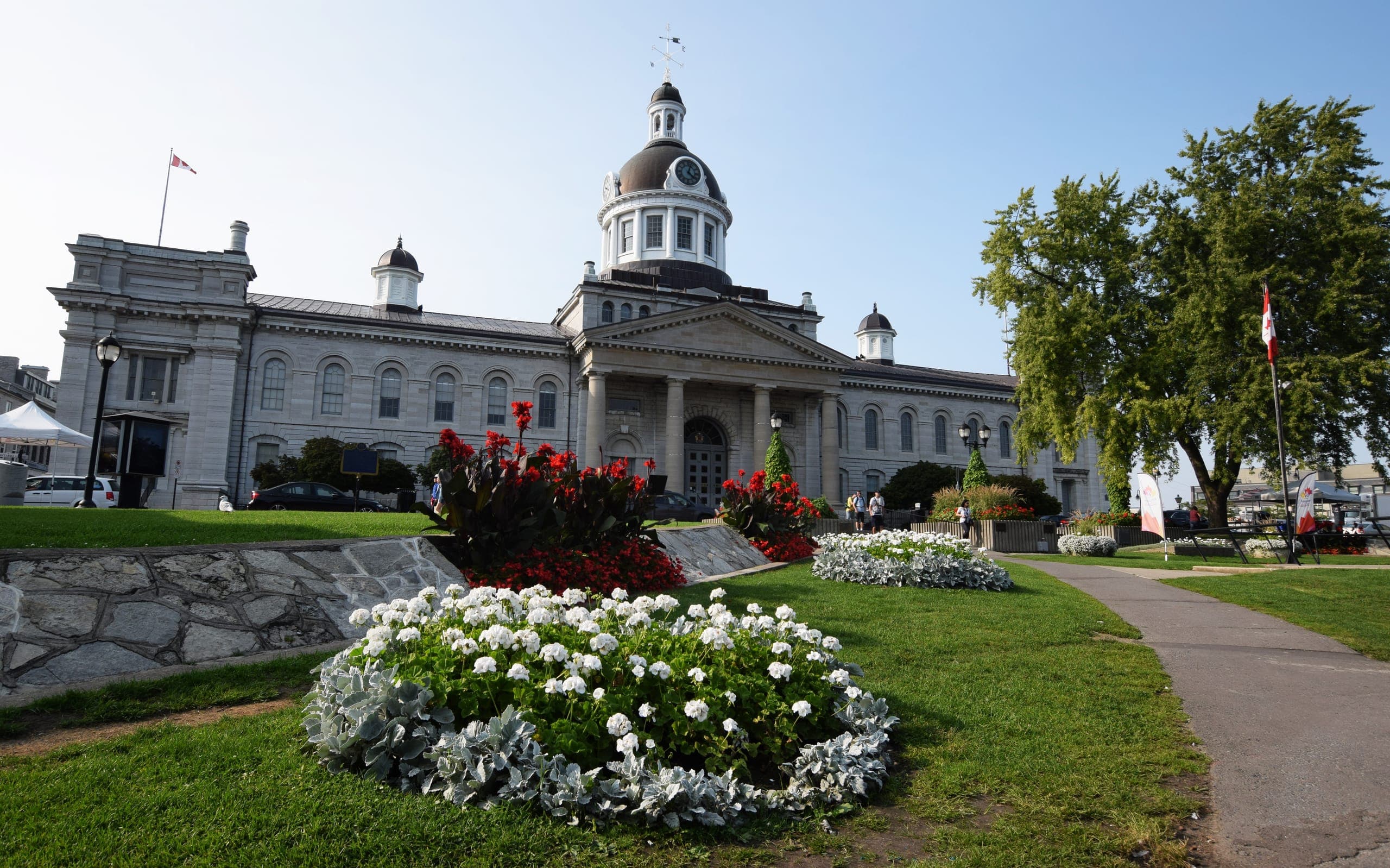 Kingston City Hall from Confederation Park, flower beds in front