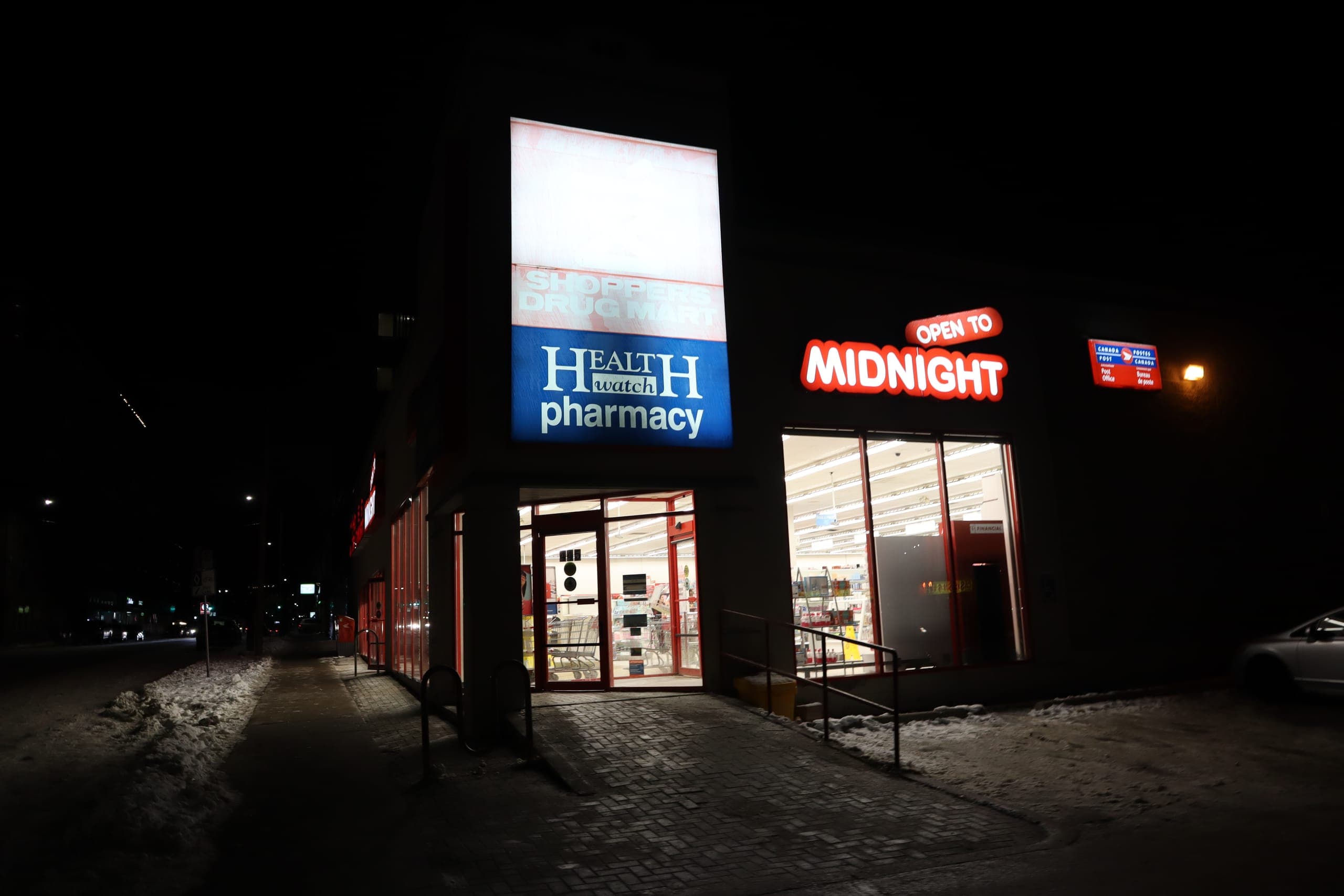 Shoppers Drug Mart at 445 Princess Street at night, lit and open